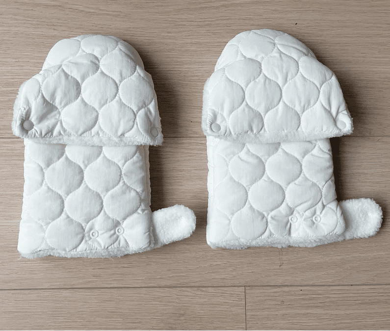 Vue arrière des gants de poussette matelassés crème, ouverts à plat avec doublure blanche et boutons-pression visibles