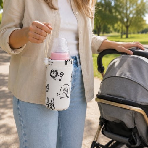 Housse pour biberon à motifs 240 ml portée par son cordon près d’une poussette