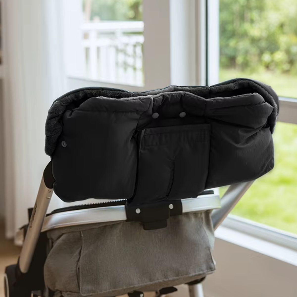 Vue arrière du manchon poussette noir avec compartiment pour mouchoirs et ouverture de distribution intégrée