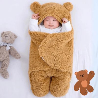 Bébé enveloppé dans un nid d’ange marron avec capuche en forme d’ourson, alliant douceur et un design adorable pour des moments uniques