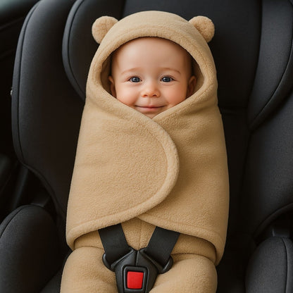 nid d’ange beige en ouate douce, bébé installé dans un cosy noir, capuche avec oreilles et look minimaliste
