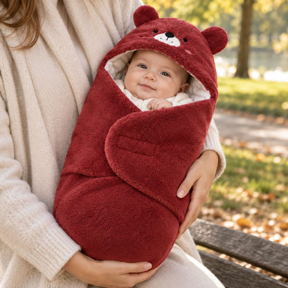 Bébé installé dans un nid d'ange 0 à 6 mois bordeaux en forme enveloppante avec motif ourson