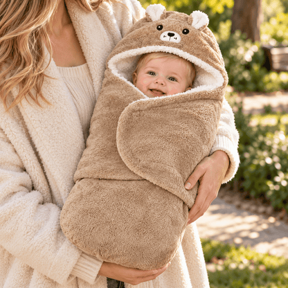 Nid d’ange bébé brun uni porté dans les bras, avec capuche à visage d’ourson, petites oreilles et doublure blanche effet moutonné