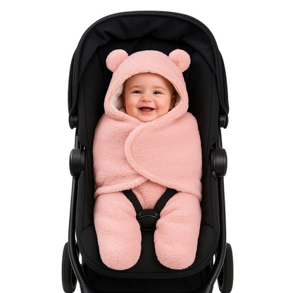 Bébé confortablement emmitouflé dans un nid d'ange bebe rose pastel, attaché en toute sécurité dans une poussette noire.