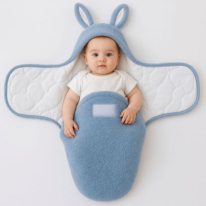 Nid d’ange cosy bleu ouvert avec bébé éveillé, capuche lapin visible