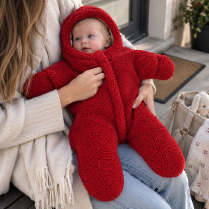 Nid d'ange bebe cosy rouge à capuche intégrée et manches longues, porté dans les bras