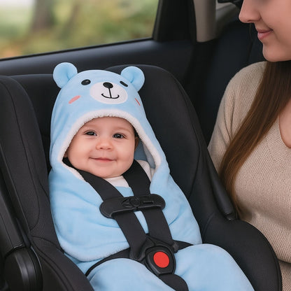 Bébé attaché dans un siège auto, habillé d’un nid d’ange bleu ciel à capuche ourson pour un confort optimal en déplacement.