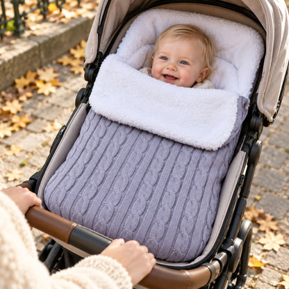 Nid d’ange polaire gris clair en maille torsadée avec doublure bouclée, bébé installé dans une poussette