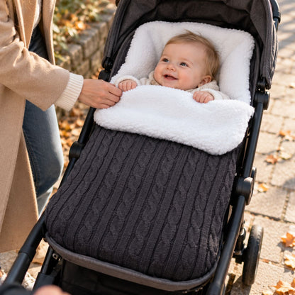 Nid d’ange polaire gris foncé en maille torsadée avec doublure bouclée blanche, bébé installé dans une poussette