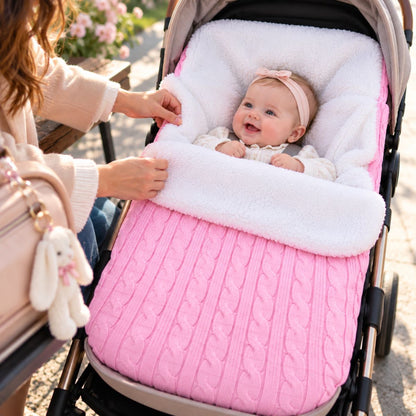Nid d’ange polaire rose clair en maille torsadée avec doublure bouclée blanche, bébé installé dans une poussette lors d’une sortie