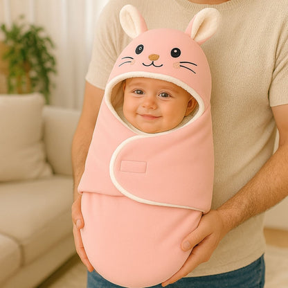Bébé souriant dans un nid d’ange rose pastel tenu dans les bras d’un adulte en intérieur lumineux