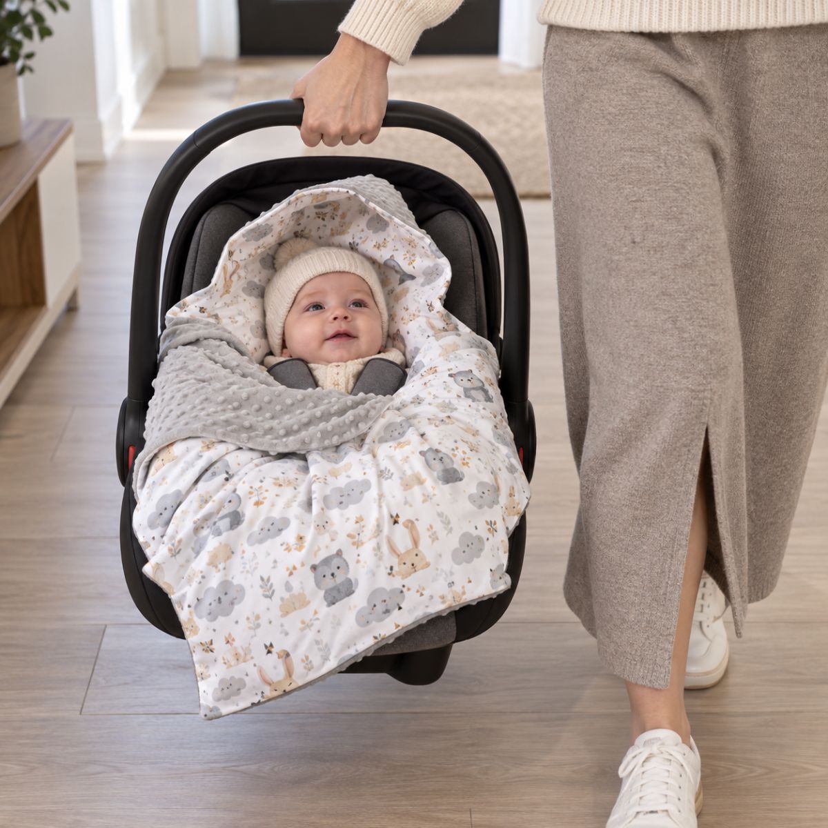 Nid d'ange siège auto motif chouette grise installé dans une coque bébé avec pans rabattables