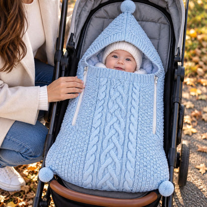 Nid d'ange tricot bleu avec maille torsadée, capuche à pompon et deux zips latéraux