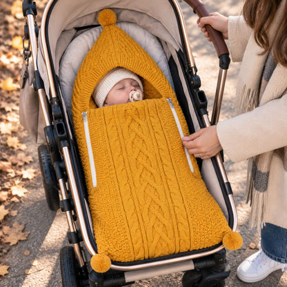 Nid d'ange tricot jaune avec maille torsadée, capuche à pompon et deux zips latéraux