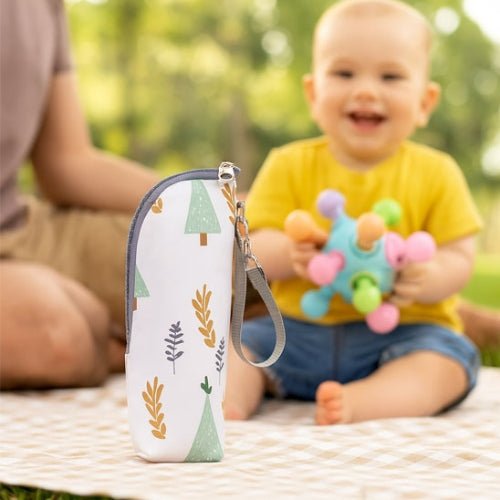 Pochette imprimée pour biberon motif forêt posée sur une couverture lors d’une sortie avec bébé