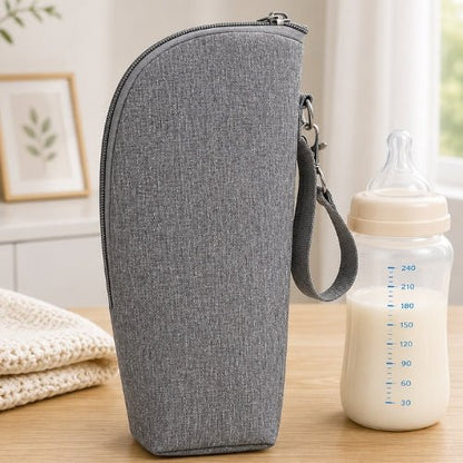Pochette imprimée pour biberon grise avec sangle amovible et fermeture zip à côté d’un biberon