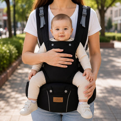 Porte-bébé 3 en 1 noir avec siège de hanche et partie à bretelles, porté face vers l’avant dans un parc