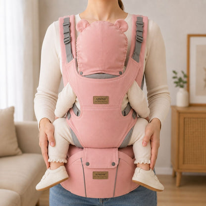 Porte-bébé 3 en 1 rose avec siège de hanche et capuche amovible déployée, porté face au porteur en intérieur