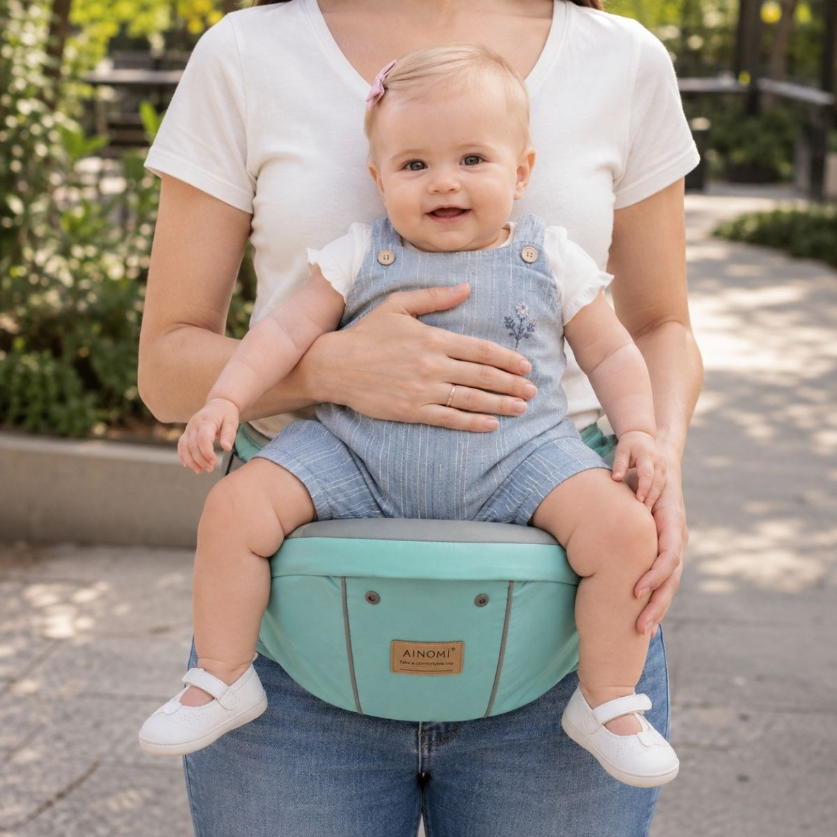 Porte-bébé 3 en 1 vert d’eau avec siège de hanche utilisé seul, porté à la taille dans un parc