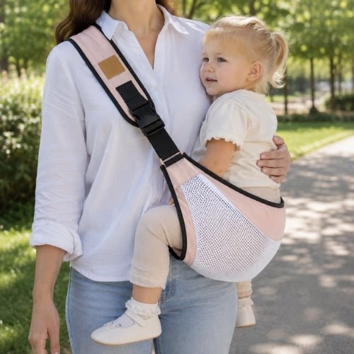Porte-bébé à une épaule en maille rose avec sangle large et réglable, porté latéralement dans un parc