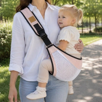 Porte-bébé à une épaule en maille rose avec sangle large et réglable, porté latéralement dans un parc