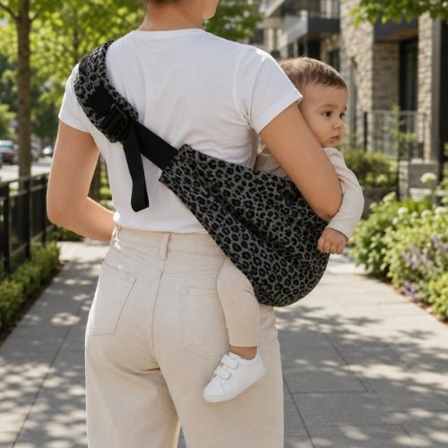 Porte-bébé à une épaule léopard gris avec épaulière large et boucle réglable, vue arrière dans une rue