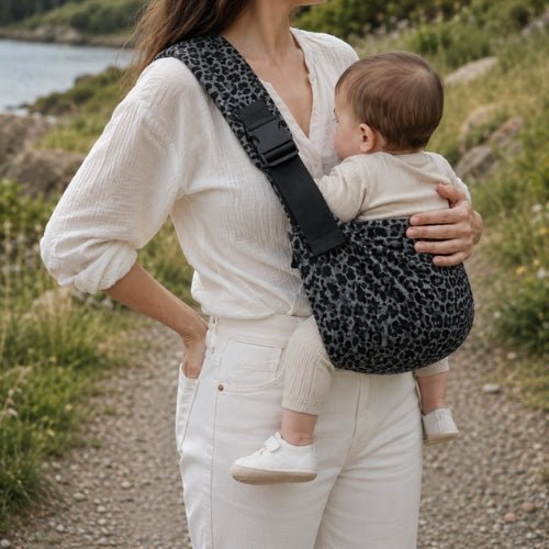 Porte-bébé à une épaule léopard gris avec épaulière large et boucle réglable, porté près de la mer