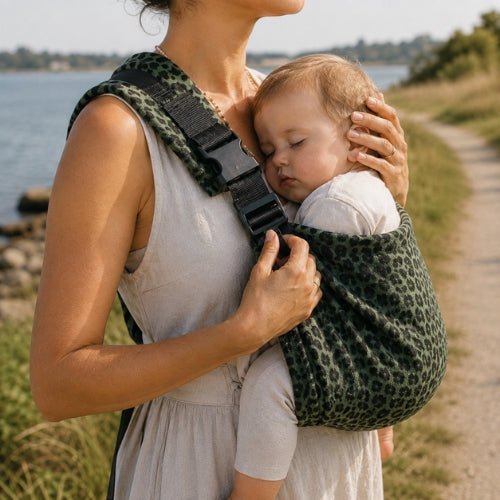 Porte-bébé à une épaule léopard vert avec épaulière large et boucle réglable, porté près de la mer