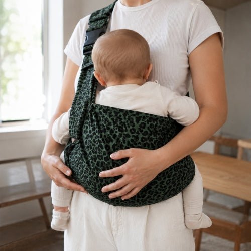 Porte-bébé à une épaule léopard vert avec épaulière large et boucle réglable, porté en intérieur