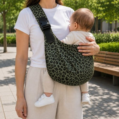 Porte-bébé à une épaule léopard vert avec épaulière large et boucle réglable, porté dans un parc