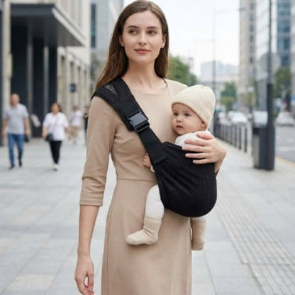 Porte-bébé à une épaule noir avec épaulière large et boucle réglable, porté en ville