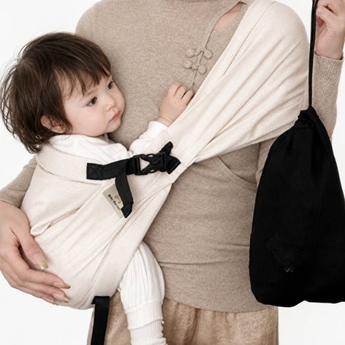 Porte-bébé à une épaule beige avec boucle réglable, vue rapprochée du portage en intérieur