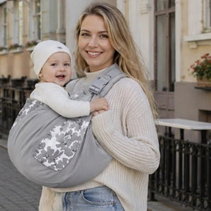 Porte-bébé à une épaule gris clair avec poche intégrée, boucle réglable et motif camouflage en ville