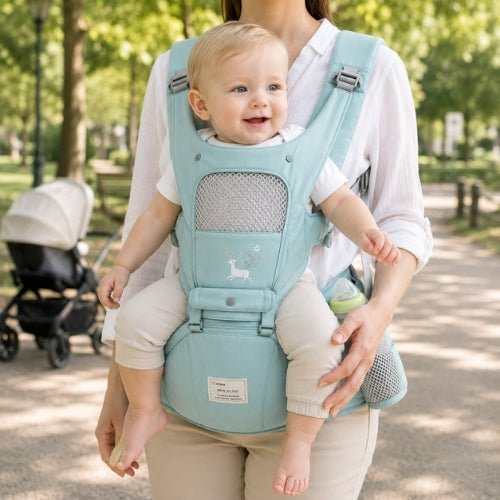 Porte-bébé avec capuche vert d’eau, panneau ouvrable et rangements, porté face vers l’avant dans un parc