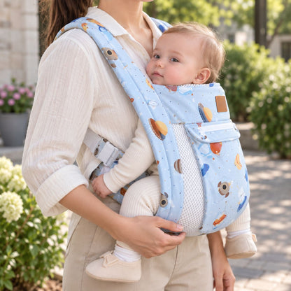 Porte-bébé avec capuche bleu ciel motif espace, vue de profil en extérieur avec bébé