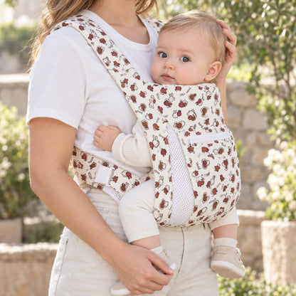 Porte-bébé avec capuche crème motif lapins, vue de face en extérieur avec bébé