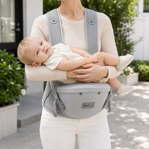 Porte-bébé avec siège détachable gris, utilisé en position horizontale sur le siège de hanche
