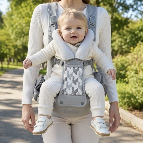 Porte-bébé avec siège détachable gris, porté face vers l’avant près d’un café