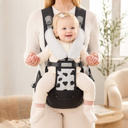 Porte-bébé avec siège détachable noir et gris, porté face vers l’avant dans un intérieur lumineux