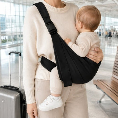 Bandouliere porte bebe noir avec boucle réglable, port latéral dans un aéroport