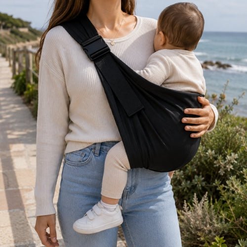 Porte bébé bandoulière noir avec boucle réglable, port latéral au bord de mer