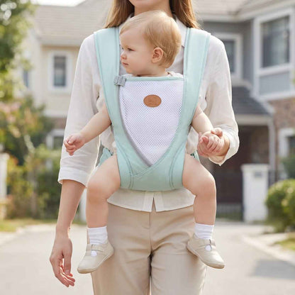 Porte-bébé croisé dans le dos vert d’eau avec bretelles larges et panneau en maille, porté face au porteur en extérieur