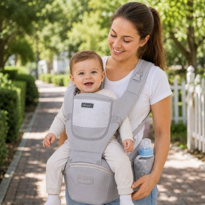 Porte bebe evolutif gris porté avec bébé en position ventrale lors d’une sortie en extérieur