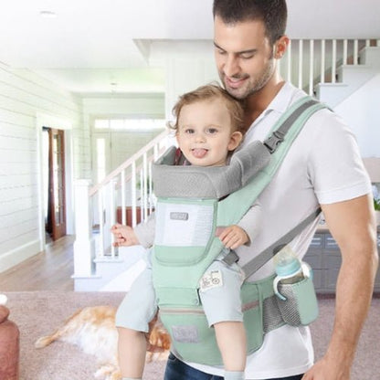 Porte bebe evolutif vert eau porté en position ventrale avec siège de hanche intégré