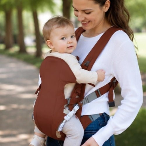 Porte bebe frontal marron porté face vers l’avant dans un parc