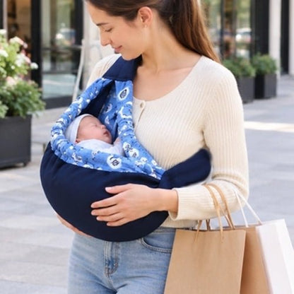 Porte bébé hamac bleu marine avec contour rembourré et sangle réglable, porté pendant une sortie en ville