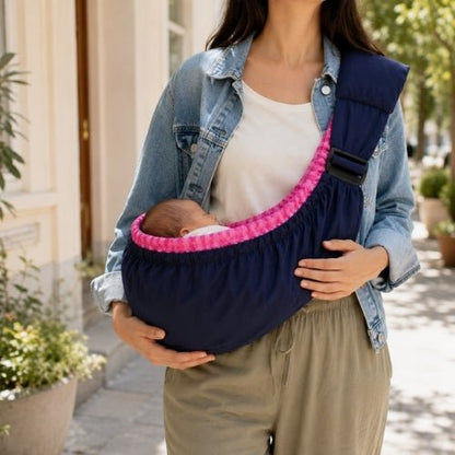 Porte bébé hamac bleu marine avec intérieur rose à carreaux, contour rembourré et sangle réglable en ville