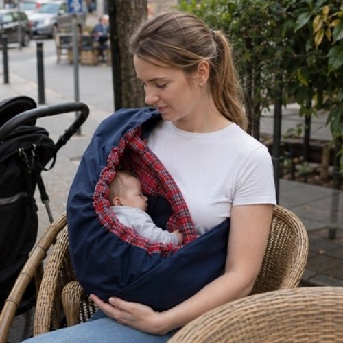 Porte bébé hamac bleu marine avec intérieur rose à carreaux, contour rembourré et sangle réglable en terrasse