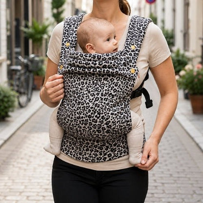 Porte bebe leopard noir et blanc porté face à face lors d'une sortie en ville