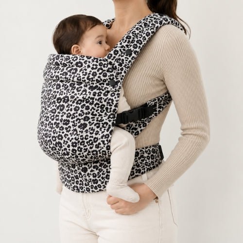 Porte bebe leopard noir et blanc porté face à face, vue de profil
